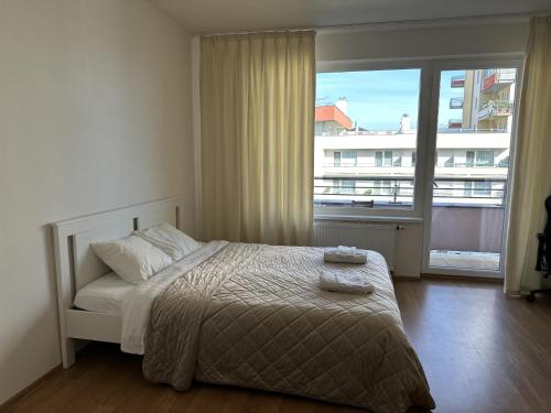 a bedroom with a bed and a large window at Nomad Apartments in Prague