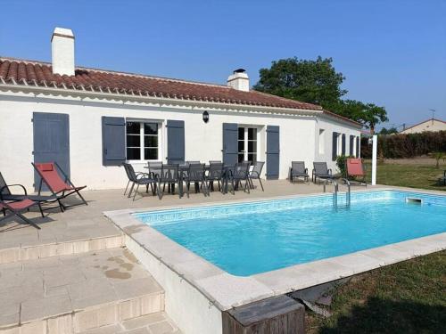 Casa con piscina, mesa y sillas en Les Bruyères Maison au calme avec piscine chauffée, en Chantonnay