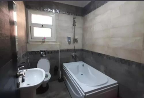 a bathroom with a white toilet and a sink at MRtavel in Cairo