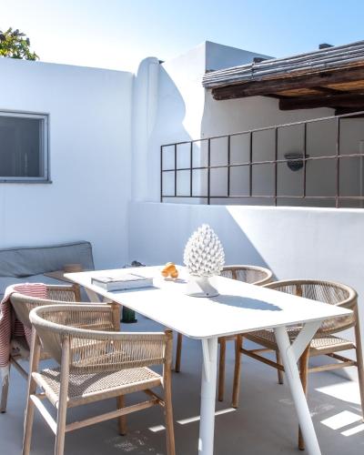 a white table and chairs on a patio at Vico San Lorenzo - Camere a Salina in Malfa