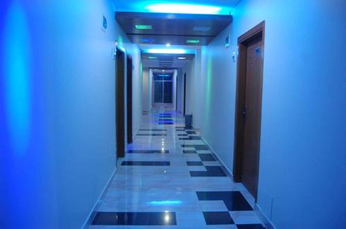 a hallway with blue lights and a tile floor at Hotel Beach Way in Cox's Bazar