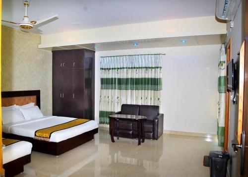 1 dormitorio con 1 cama, 1 silla y 1 mesa en Beach Way, en Cox's Bazar
