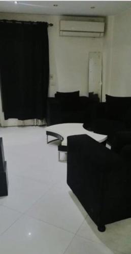 Habitación con muebles negros y suelo blanco. en Badr, en El Cairo
