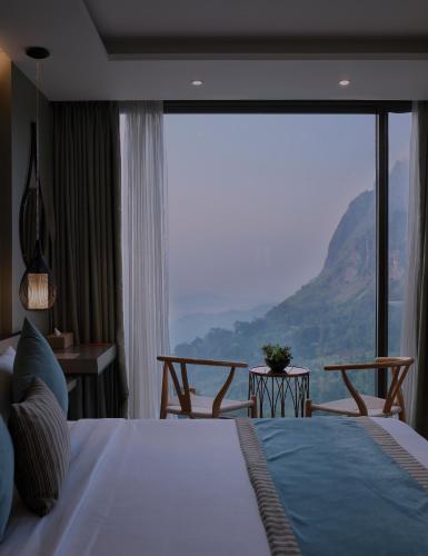 a bedroom with a bed with a view of a mountain at HIDE ELLA Hotel & Resort in Ella