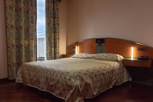a bedroom with a bed with a wooden headboard and a window at Hotel San Nicola in Lagonegro