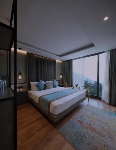 a bedroom with a large bed and a large window at HIDE ELLA Hotel & Resort in Ella