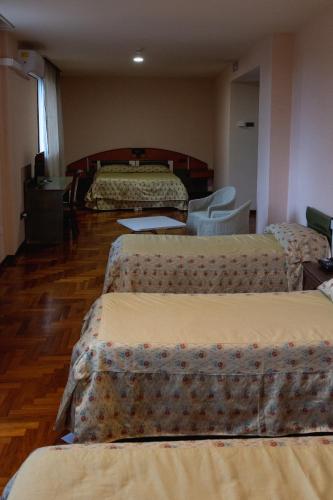 a hotel room with three beds and a table at Hotel San Nicola in Lagonegro