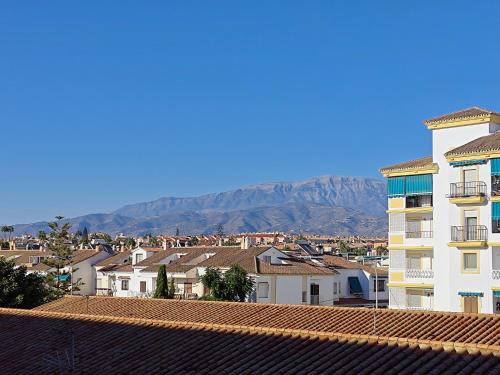 Apartamento en Torre del Mar في توري ذيل مار: مدينة فيها مباني وجبال في الخلف