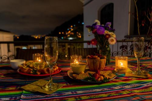 uma mesa com pratos de comida, copos de vinho e velas em La Banksia Hotel em Quito