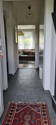 a hallway with a rug and a room with a bed at Edel Apartments Dulliken in Dulliken