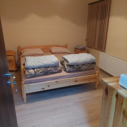 2 camas sentadas en una cama de madera en una habitación en Guest Rooms Didka en Koprivshtitsa