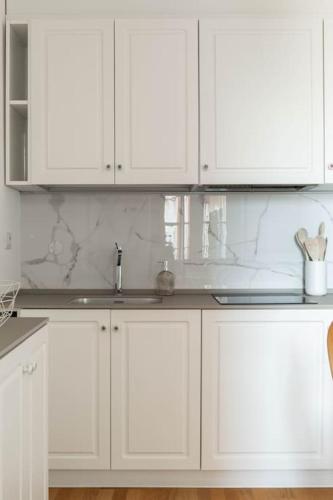 a white kitchen with white cabinets and a sink at La Vacanza Bellagio in Bellagio