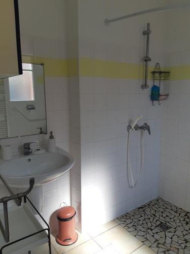 une salle de bain blanche avec une douche et un lavabo dans l'établissement Appt plein coeur de Soulac sur Mer, à Soulac-sur-Mer
