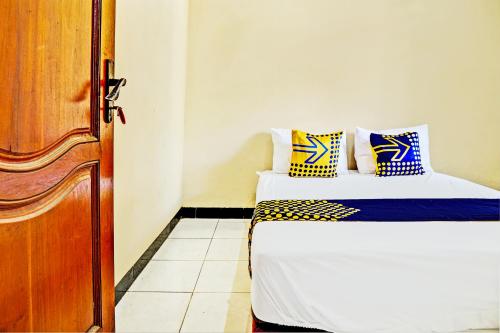 um quarto com uma cama e uma porta de madeira em OYO 93107 Homestay H Syarif Syariah – Bandar Gresik em Gresik