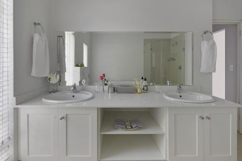 a bathroom with two sinks and a large mirror at Fransvliet Guest House in Franschhoek