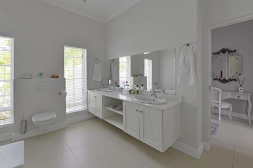 a white bathroom with a sink and a toilet at Fransvliet Guest House in Franschhoek