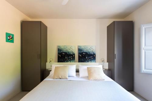 a bedroom with a large white bed with two pillows at Vico San Lorenzo - Camere a Salina in Malfa