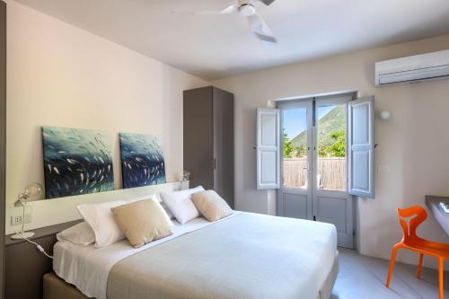 1 dormitorio con cama blanca y ventana en Vico San Lorenzo - Camere a Salina, en Malfa