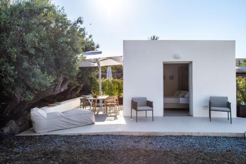 a patio with a couch and a table and chairs at Vico San Lorenzo - Camere a Salina in Malfa