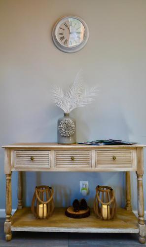 a table with a clock on the wall and two baskets at Farm Country House with Pool and Huge Property in Blakeslee