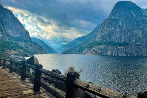 a wooden bridge over a lake with mountains in the background at Big Creek Hideaway in Groveland