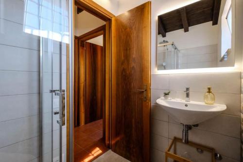 ein Bad mit einem Waschbecken und einem Spiegel in der Unterkunft Casa delle Ochette in Costermano sul Garda