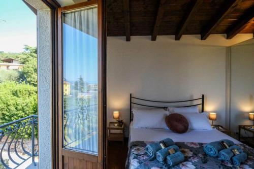 ein Schlafzimmer mit einem Bett neben einem Balkon in der Unterkunft Casa delle Ochette in Costermano sul Garda