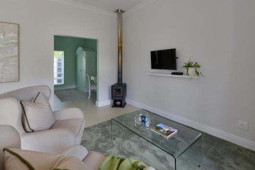 a living room with a couch and a glass table at Fransvliet Guest House in Franschhoek