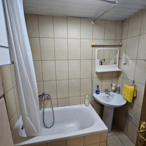 ein Badezimmer mit einer Badewanne und einem Waschbecken in der Unterkunft Sunshine Apartment Podgorica in Podgorica