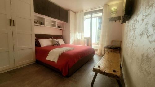 a bedroom with a red bed and a window at Alpine House in Sauze dʼOulx