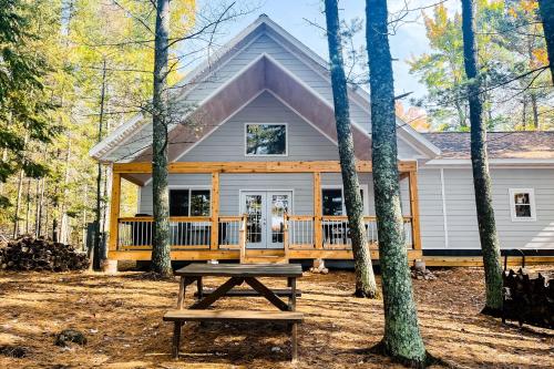 a house with a picnic table in front of it at Chalet on the Bay in Saint Germain