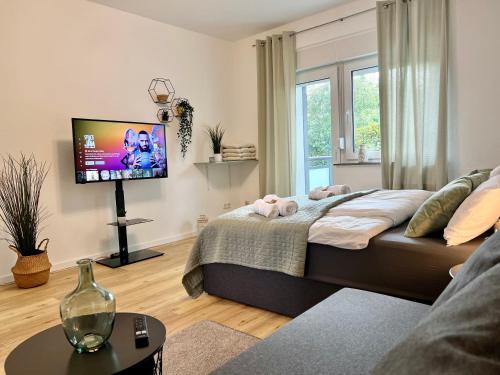 een woonkamer met 2 bedden en een flatscreen-tv bij Design Apartment mit Balkon - Küche - Netflix in Essen
