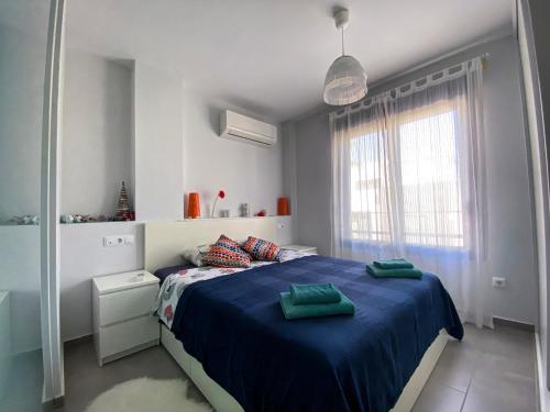 a bedroom with a blue bed and a window at Luxury House Villamartin Zenia in Alicante