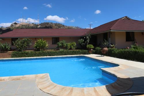 a swimming pool in front of a house at Domiya Estate Ltd in Dodoma