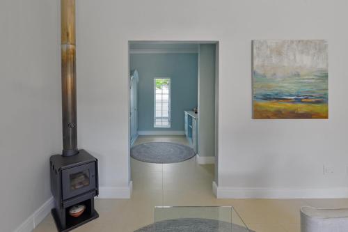 a living room with a stove and a painting at Fransvliet Guest House in Franschhoek