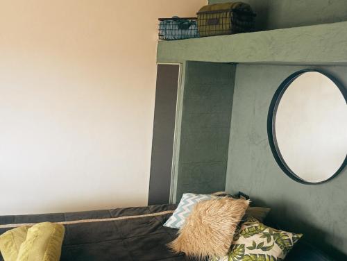 a mirror on a wall next to a couch with a mirrorigunigun at RevolucionArte Potrerillos in Ciudad Lujan de Cuyo