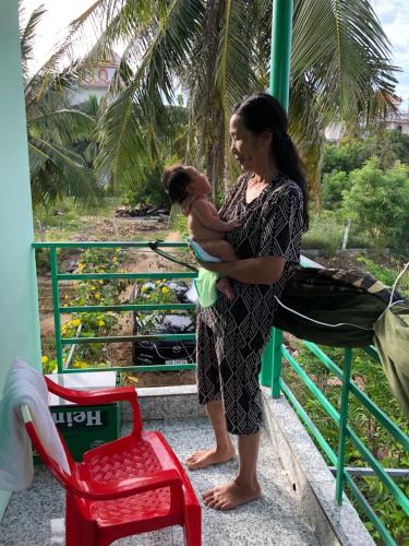 una mujer sosteniendo un bebé en un tren en sau khách sạn phong lan, en Phan Rang