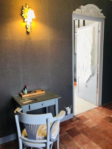 a room with a desk and a chair next to a door at Suite en Chambre d'hôtes La Vigenna in Les Ormes