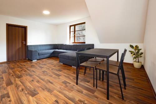 a living room with a table and a couch at Apartmány Tamnakonci in Deštné v Orlických horách
