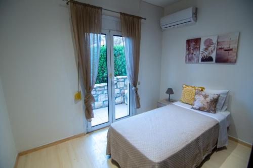 a bedroom with a bed and a sliding glass door at Cicada 4 Bedroom Villa in Palaiokastro