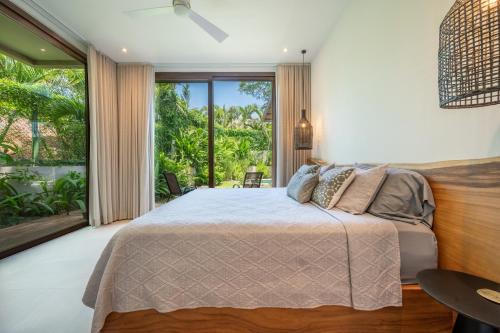 a bedroom with a bed and a large window at Casa Cheetah Main House and Casita in Tamarindo