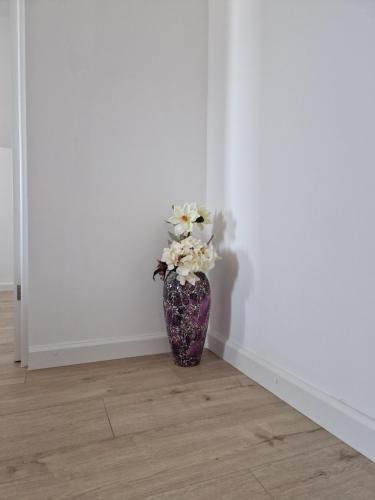 eine lila Vase mit Blumen in einem Zimmer in der Unterkunft Fortress Apartament in Oradea