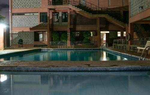 an empty swimming pool in front of a building at The Luke Hotel Cravers Thika in Thika