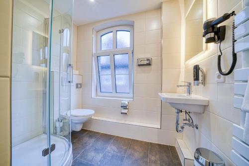 a bathroom with a toilet and a sink and a shower at Zentrum Hotel Stade in Stade