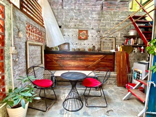 uma mesa e duas cadeiras num quarto com uma parede de tijolos em Chez Phuong Cat Ba -Private entire house em Ilha de Cát Bà