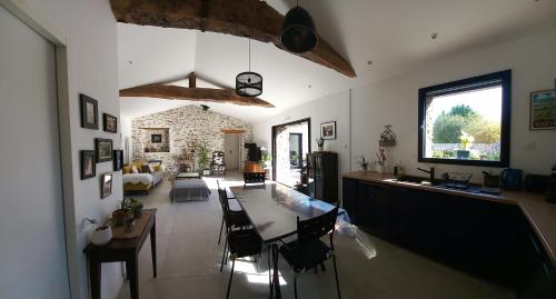 a kitchen and living room with a table and chairs at La villa du pressoir, classé 3 étoiles meublé de tourisme in Le Pallet