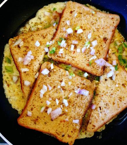 four pieces of toast with onions on a frying pan at Oolala - Your lake house in the center of Udaipur in Udaipur