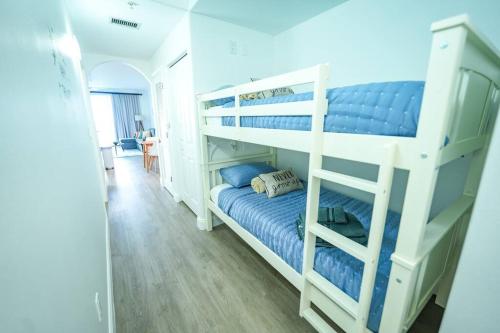 1 Schlafzimmer mit 2 Etagenbetten mit blauer Bettwäsche in der Unterkunft Orlando Apt 9th Floor 5 min from Disney in Orlando
