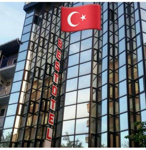 un edificio con una bandera delante de él en Best otel, en Sandıklı