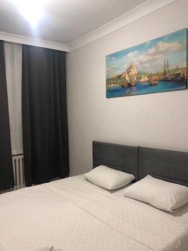 1 dormitorio con 1 cama con una pintura en la pared en Best otel en Sandıklı